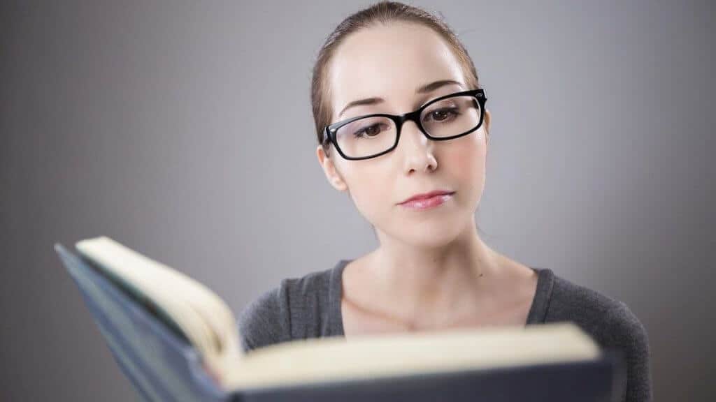 a millennial woman reads a book about cheap hobbies